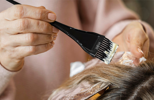 A closeup of someone brushing hair product onto someone's hair