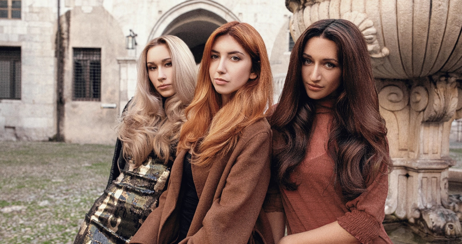 Three women standing next to each other, they're outdoors and they are looking at the camera